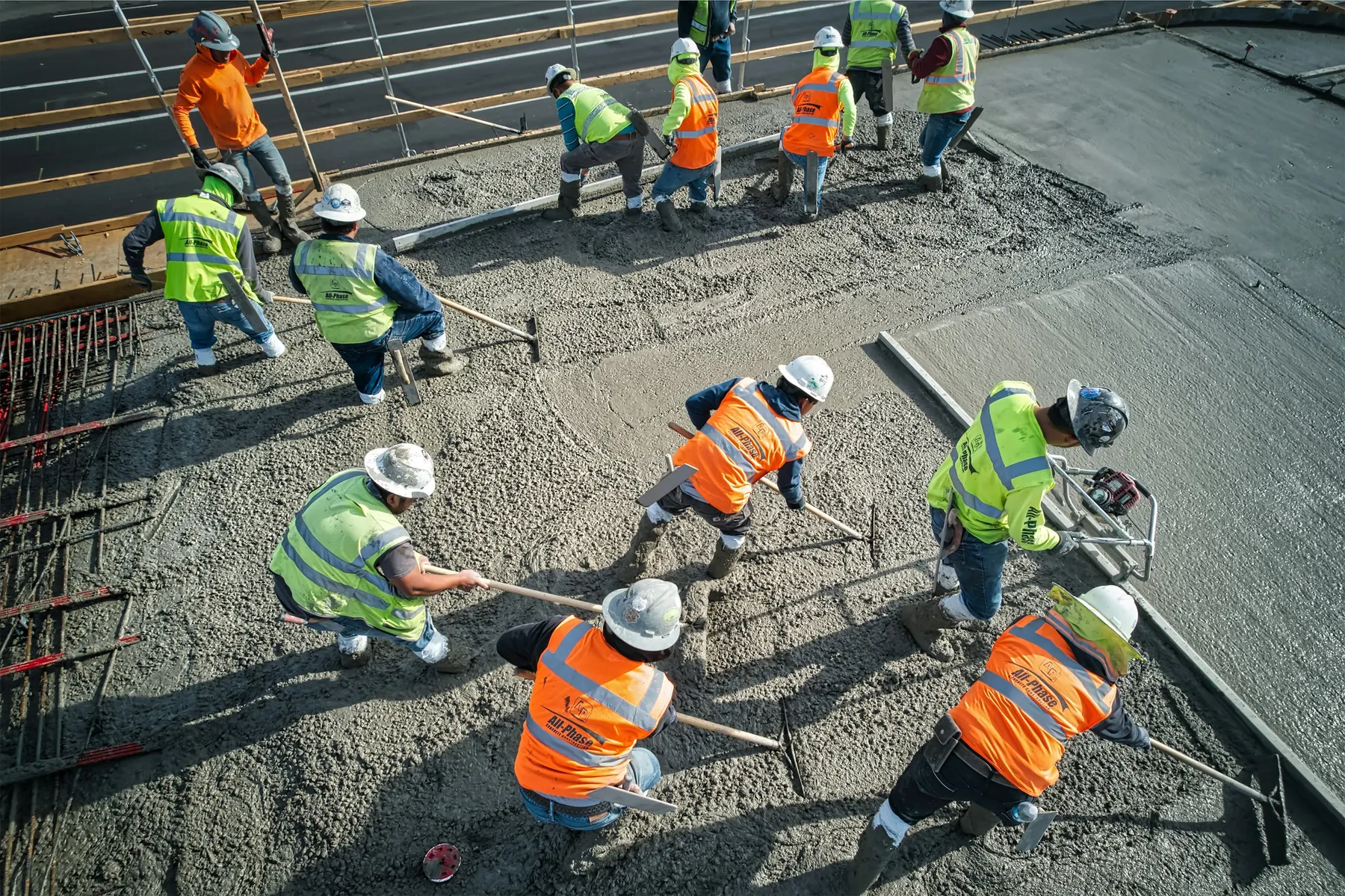 Construction crew pouring and spreading concrete