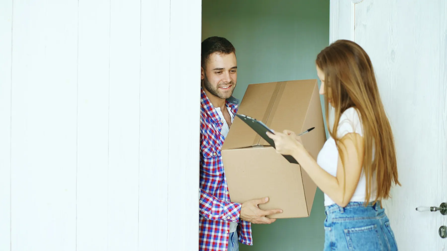 Couple receiving a package delivery at their front door