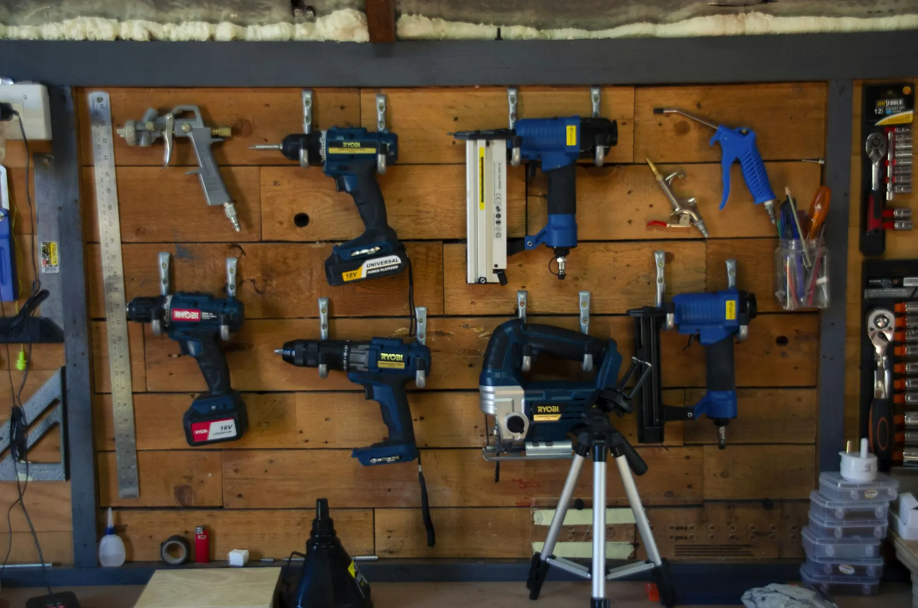 Power tools hanging in rows on a workshop wall